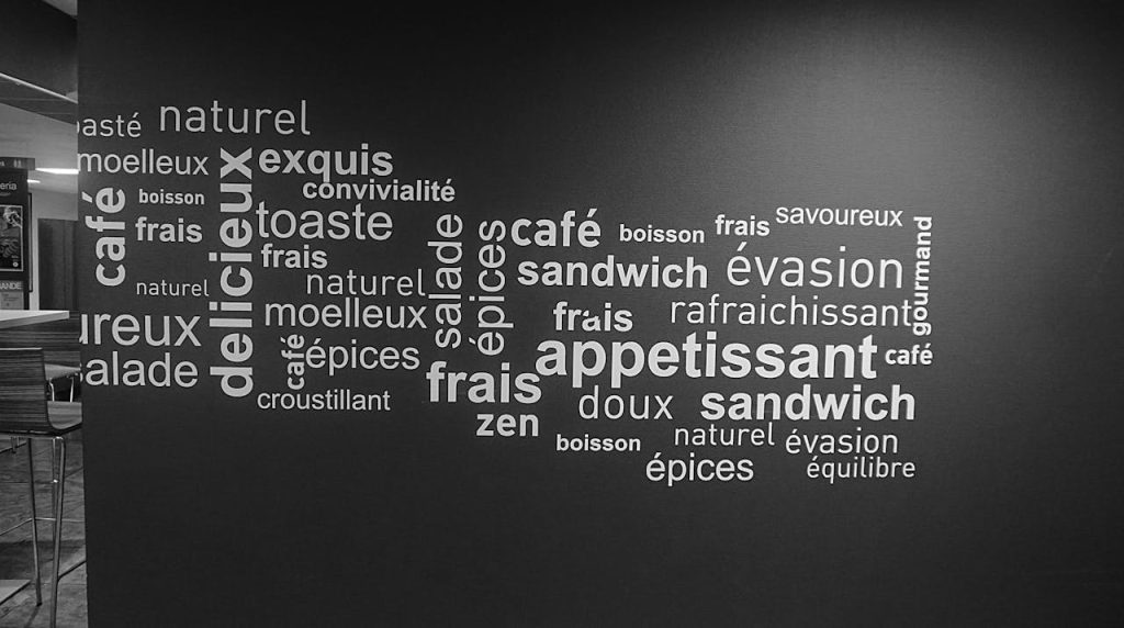pexels photo 241832 Monochrome word art on a cafe wall featuring French culinary terms.