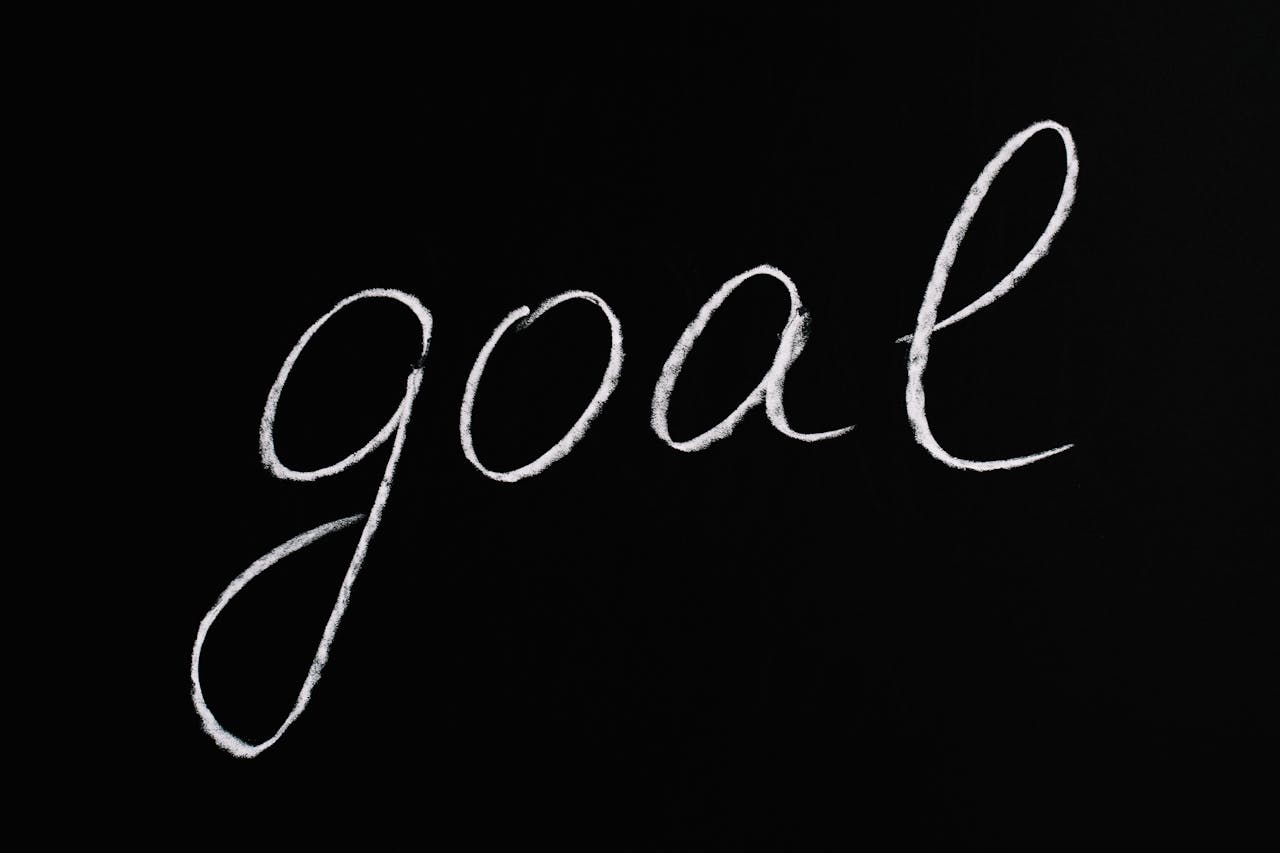 Services Elegant handwritten 'goal' on a black chalkboard background conveying ambition and purpose.